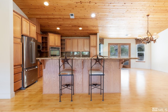 kitchen with a kitchen bar, light stone counters, stainless steel appliances, and wooden ceiling