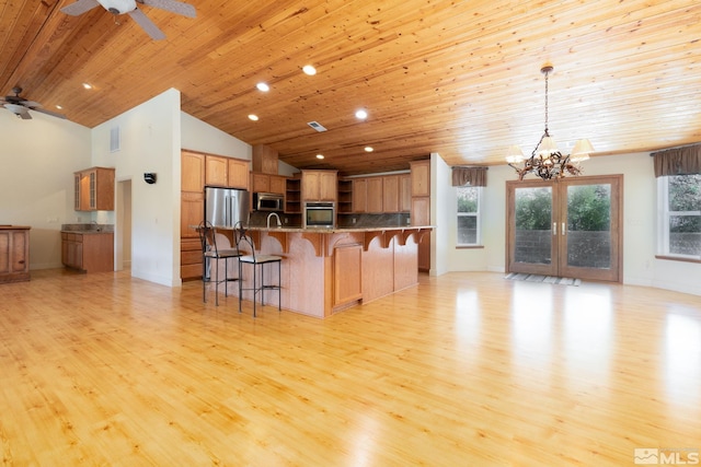 kitchen with appliances with stainless steel finishes, decorative light fixtures, wooden ceiling, and light hardwood / wood-style floors