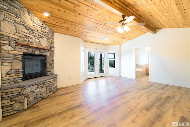 unfurnished living room with french doors, light wood-type flooring, wood ceiling, lofted ceiling with beams, and a fireplace