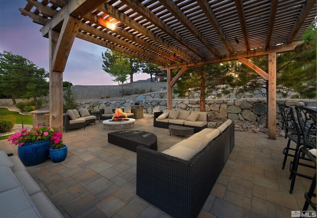 patio terrace at dusk featuring an outdoor living space with a fire pit and a pergola