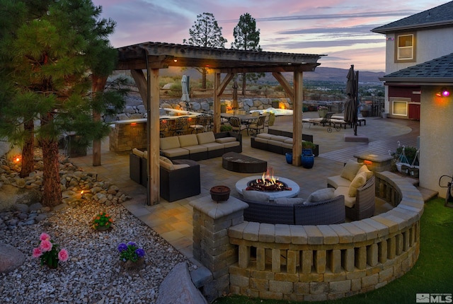 patio terrace at dusk with an outdoor living space with a fire pit