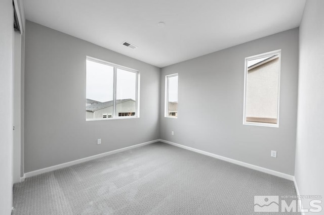 carpeted spare room featuring plenty of natural light