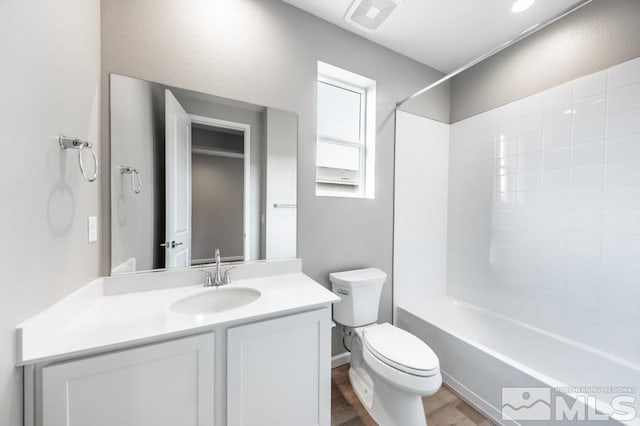 full bathroom with shower / tub combination, vanity, hardwood / wood-style flooring, and toilet