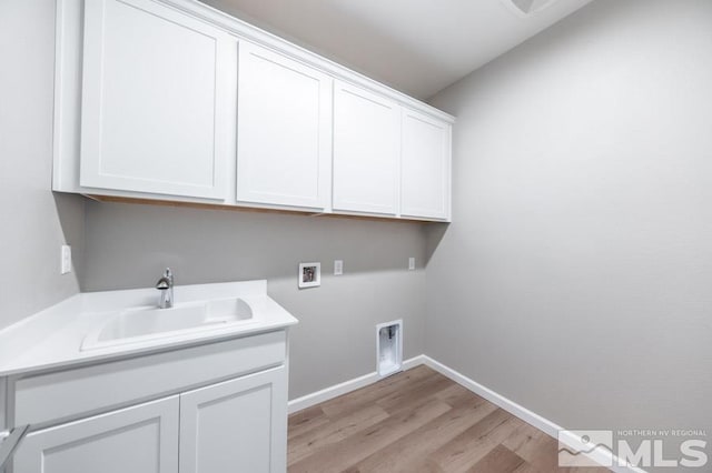 laundry room with cabinets, hookup for a washing machine, light wood-type flooring, electric dryer hookup, and sink