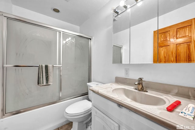 full bathroom with enclosed tub / shower combo, toilet, and vanity