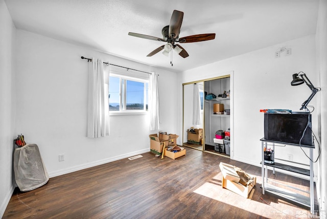 interior space with a closet, ceiling fan, and dark hardwood / wood-style flooring