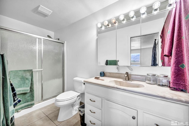 bathroom featuring a textured ceiling, vanity, walk in shower, tile patterned flooring, and toilet