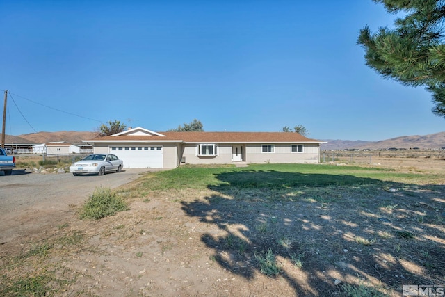 single story home with a mountain view, a garage, and a front lawn