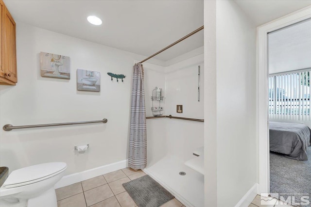 bathroom featuring toilet, a shower with curtain, and tile patterned flooring