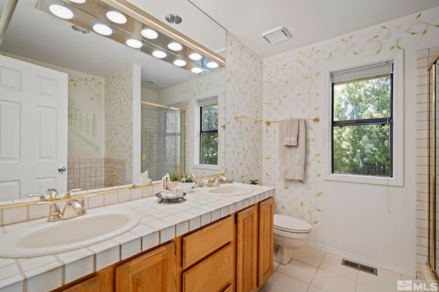 bathroom featuring tile patterned floors, toilet, an enclosed shower, and vanity