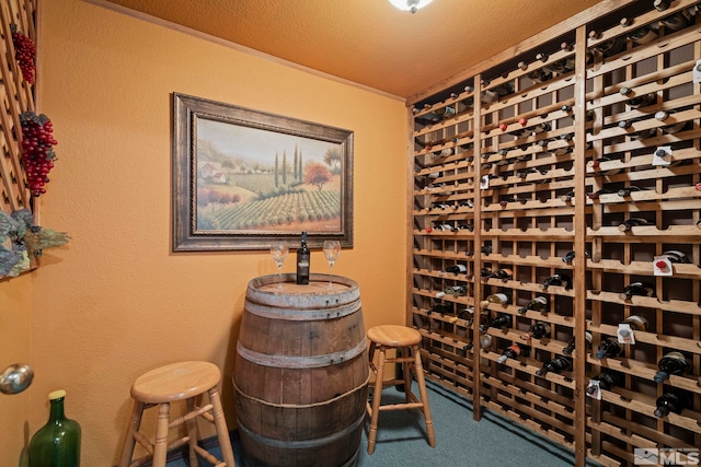 wine area featuring carpet floors and a textured ceiling