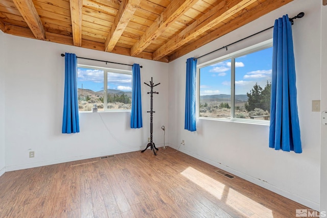 unfurnished room featuring wood ceiling, a wealth of natural light, and wood-type flooring