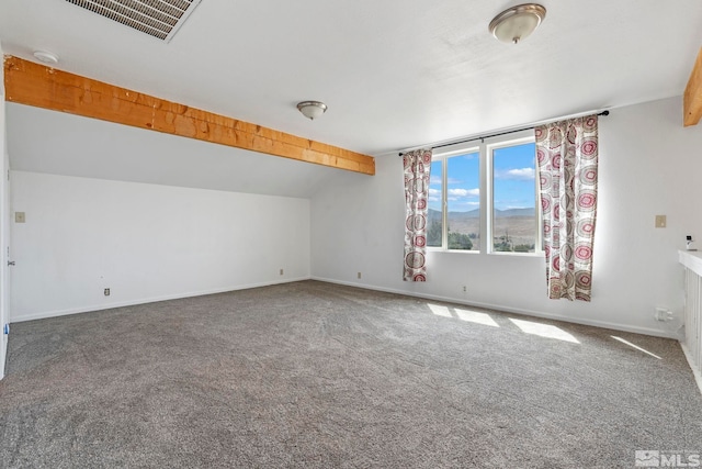 carpeted spare room with vaulted ceiling