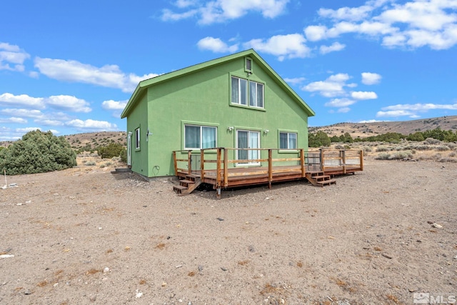 back of property with a deck with mountain view