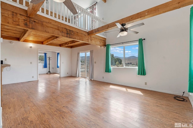 unfurnished living room with ceiling fan, a wealth of natural light, and light hardwood / wood-style floors