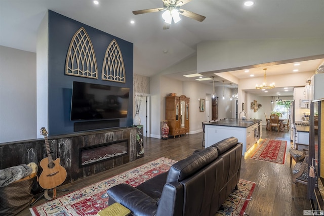 living room with ceiling fan with notable chandelier, lofted ceiling, dark wood-style floors, and a fireplace