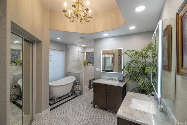 bathroom featuring recessed lighting, a freestanding tub, two vanities, and a sink