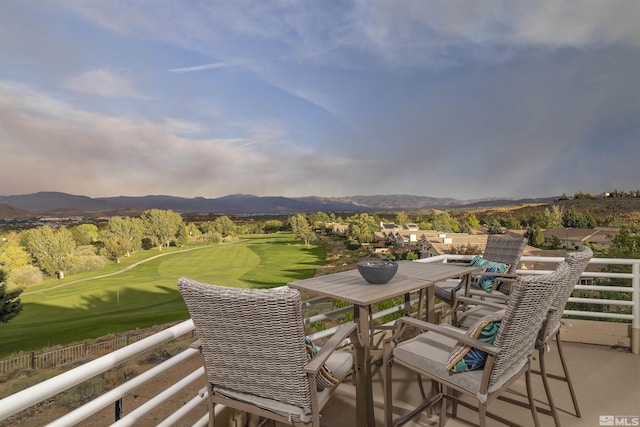 view of patio featuring a balcony, golf course view, and a mountain view