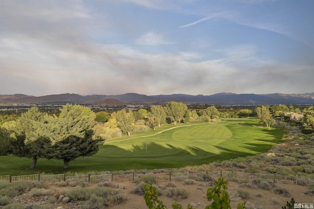 view of community with a mountain view, golf course view, and fence