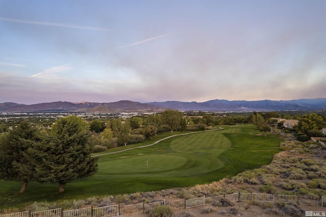 view of community featuring a mountain view, view of golf course, and fence