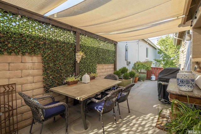 view of patio / terrace with grilling area, outdoor dining space, and fence