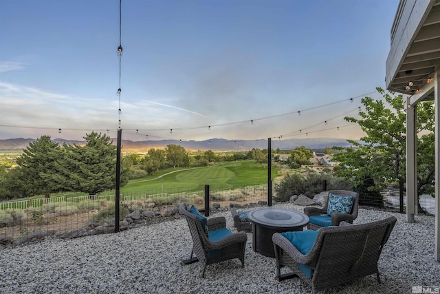 patio terrace at dusk with a fenced backyard and an outdoor fire pit