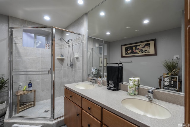 bathroom featuring double vanity, a stall shower, and a sink