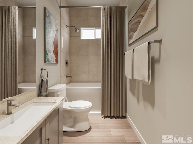 full bathroom featuring hardwood / wood-style floors, toilet, tiled shower / bath combo, and vanity