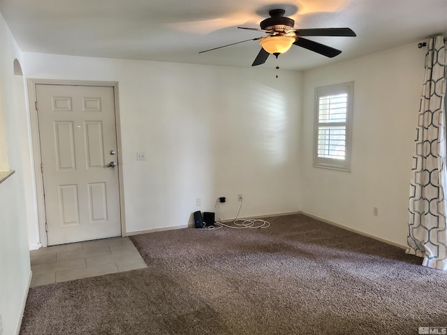 carpeted spare room with ceiling fan