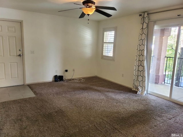 carpeted spare room featuring ceiling fan and a wealth of natural light