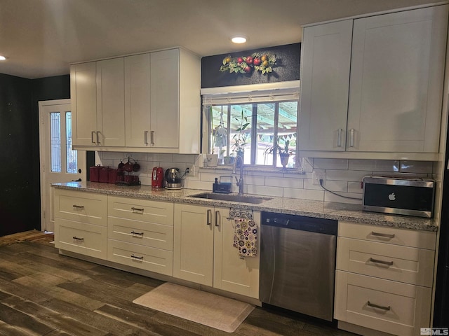 kitchen with white cabinets, backsplash, stainless steel appliances, dark hardwood / wood-style flooring, and sink