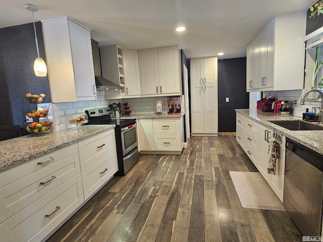 kitchen featuring stainless steel appliances, white cabinetry, sink, dark hardwood / wood-style floors, and pendant lighting