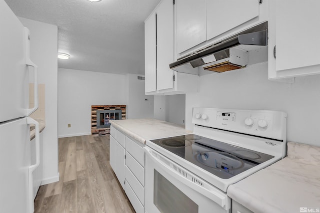 kitchen with light wood-type flooring, under cabinet range hood, white appliances, white cabinets, and light countertops