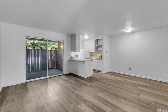 unfurnished living room with hardwood / wood-style floors, a textured ceiling, and sink