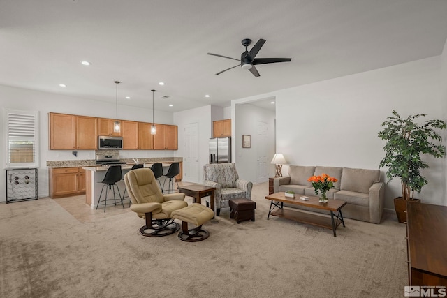 living area with recessed lighting, light carpet, and a ceiling fan