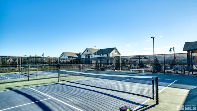 view of tennis court featuring fence