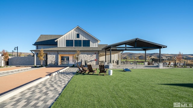 exterior space with a yard, a gazebo, stone siding, board and batten siding, and a mountain view