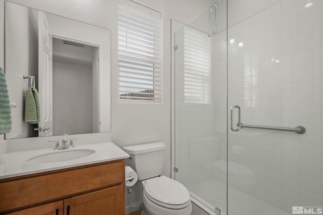 full bath with vanity, toilet, visible vents, and a stall shower