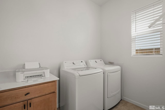 washroom with washer and dryer, baseboards, and cabinet space