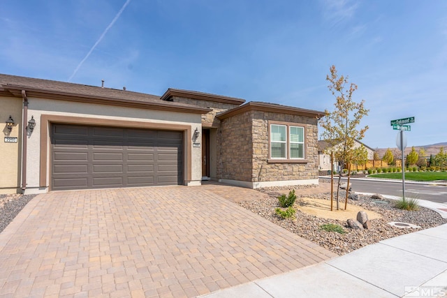 view of front of home with stone siding, stucco siding, decorative driveway, and a garage