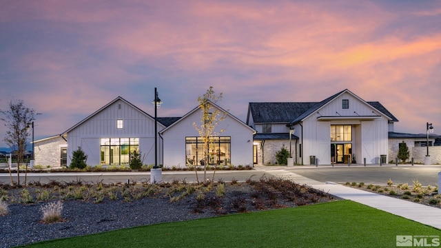 modern farmhouse featuring a lawn and board and batten siding