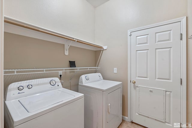 washroom featuring light tile patterned floors and washing machine and clothes dryer