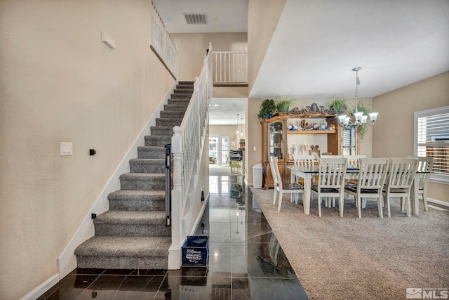 staircase featuring carpet and an inviting chandelier