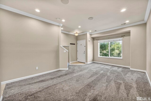 empty room with ornamental molding and light colored carpet