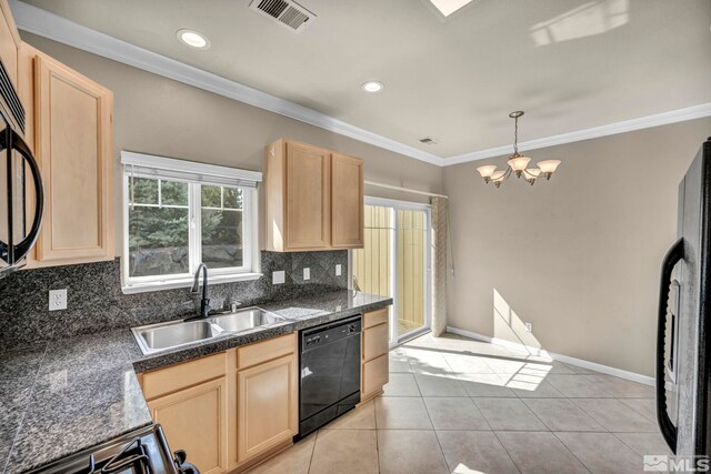 kitchen featuring stainless steel appliances, sink, light brown cabinets, and a chandelier