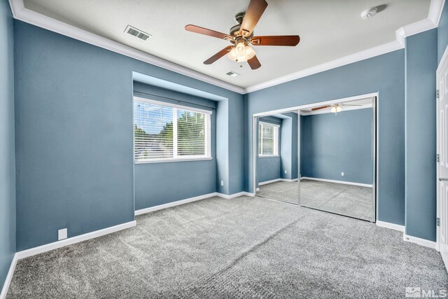 unfurnished bedroom with carpet, ceiling fan, ornamental molding, and a closet