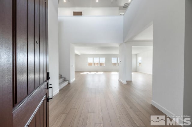 entryway featuring light hardwood / wood-style flooring and a towering ceiling