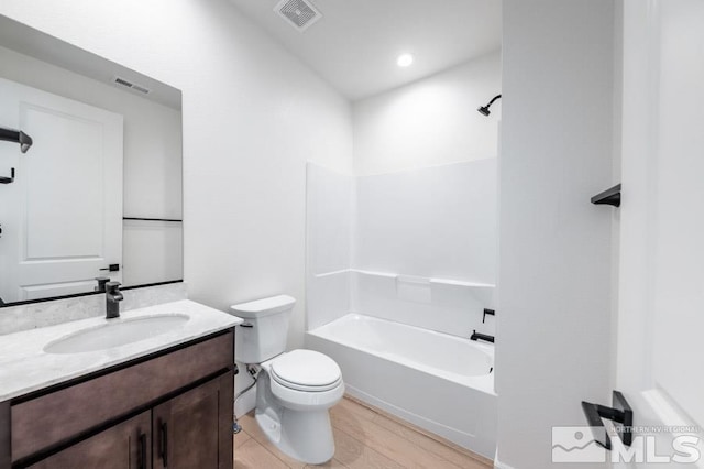 full bathroom with vanity, bathing tub / shower combination, toilet, and hardwood / wood-style flooring