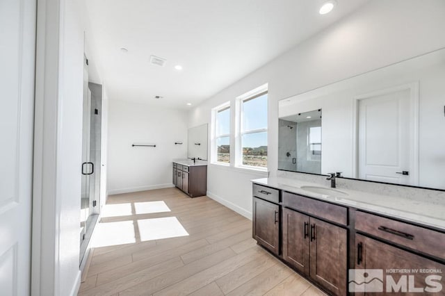 bathroom featuring walk in shower, vanity, and hardwood / wood-style flooring