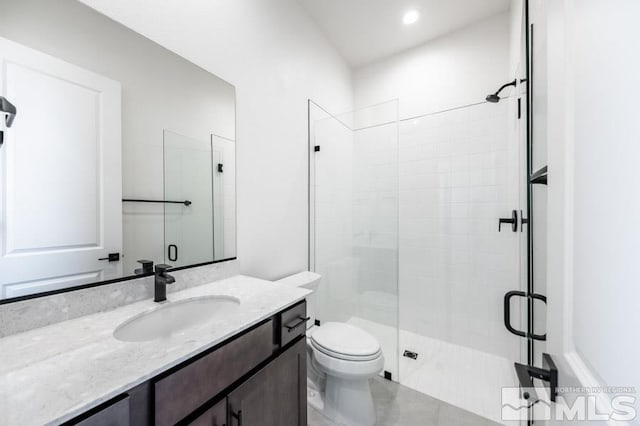 bathroom featuring tile patterned flooring, vanity, toilet, and an enclosed shower